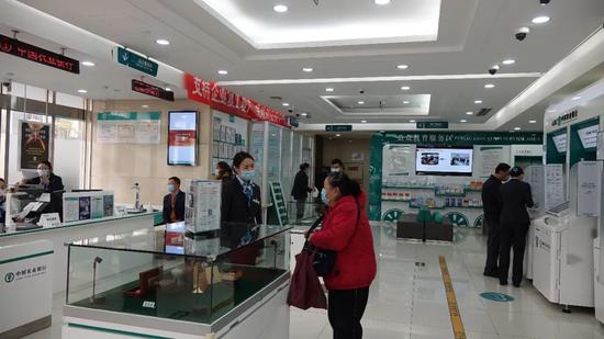 （圖為一位老年人在農業銀行北京鐵道支行咨詢業務。）