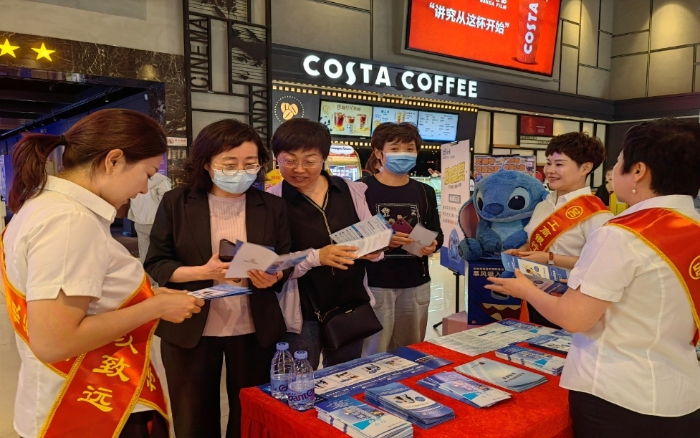 工作人員為群眾發放反詐宣傳手冊